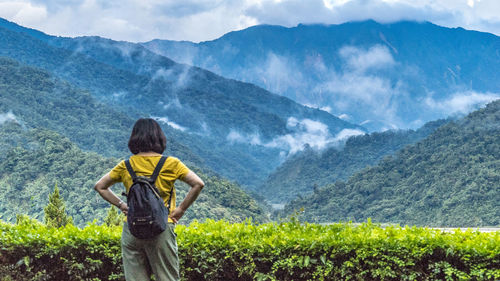 Rear view of woman looking at scenic view of mountains