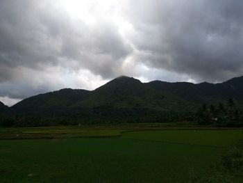 Scenic view of field and mountains against sky