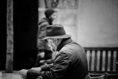 Side view of man sitting on railing