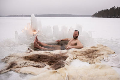 Portrait of happy mature man enjoying ice bath at frozen lake