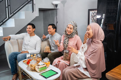 Portrait of smiling friends sitting at home