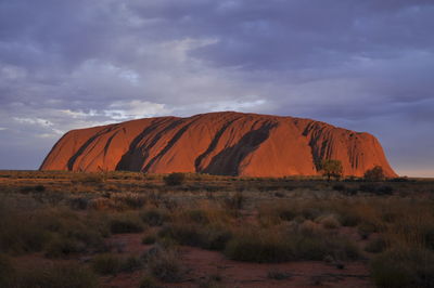 Rock formations on field against sky