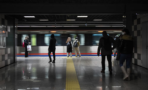 Rear view of people walking in subway