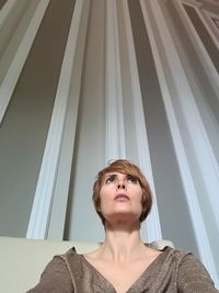 Low angle view of young woman looking up