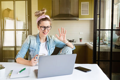 Businesswoman looking at laptop while sitting at home