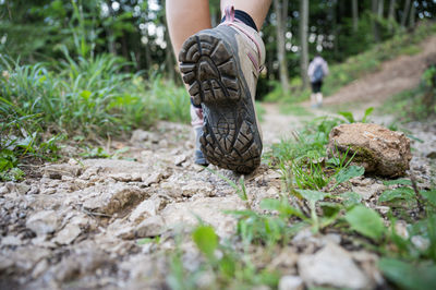 Low section of person walking on field