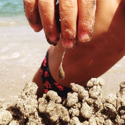 Low section of person on sand at beach