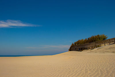 Scenic view of desert against blue sky