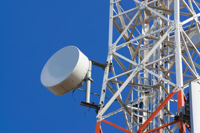 Low angle view of ferris wheel against clear blue sky