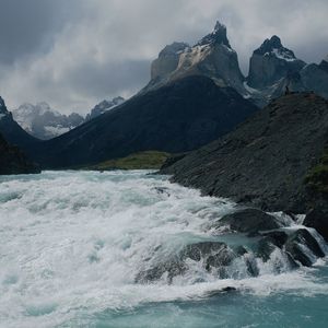 Scenic view of waterfall and mountains against sky