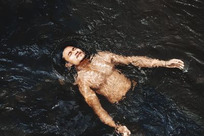 High angle view of woman lying in water