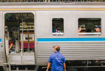 Rear view of man working at train