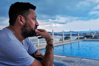 Side view of man in swimming pool against sea