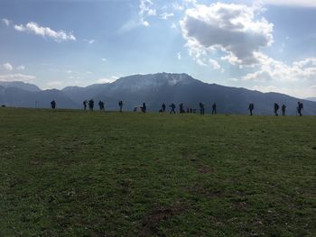 Group of people on field against sky