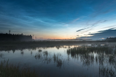 Scenic view of lake and windmills with noctilucent clouds during summer midnight sun