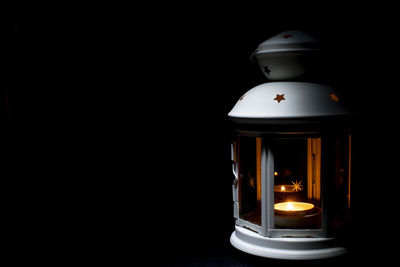 Close-up of illuminated lamp against black background