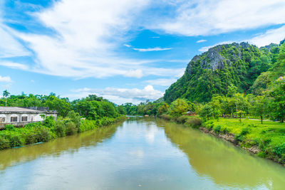 Scenic view of river amidst trees against sky