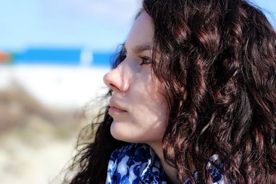 Close-up of young woman with eyes closed against sky