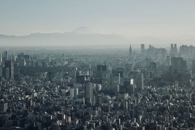 Aerial view of buildings in tokyo against sky