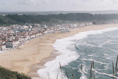 High angle view of city by sea against sky