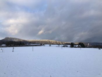 Snow covered landscape against sky