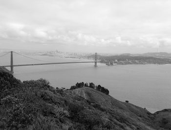 Scenic view of suspension bridge over sea against sky