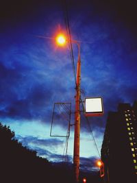 Low angle view of illuminated street light against sky at sunset