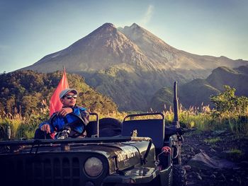 Portrait of man sitting against mountains