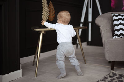 Rear view of boy sitting on chair at home