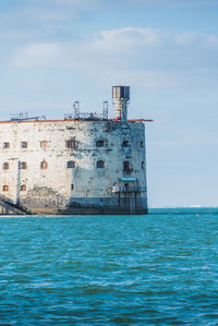 Building by sea against sky