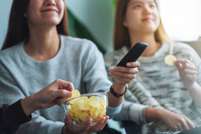 Friends eating potato chips while watching tv together