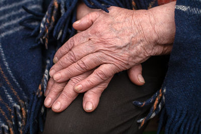 Midsection of man with hands clasped