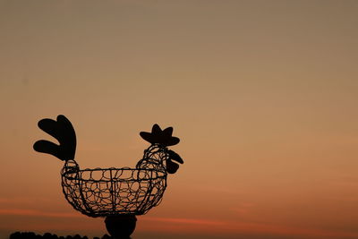 Close-up of silhouette metal against orange sky