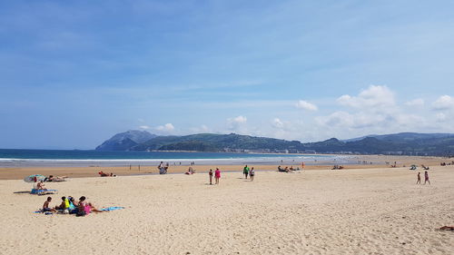 People at beach against sky