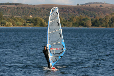 Full length of man windsurfing in sea