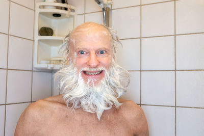 Portrait of a smiling young man in bathroom