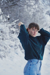 Portrait of young beautiful woman, waist up, standing in snow