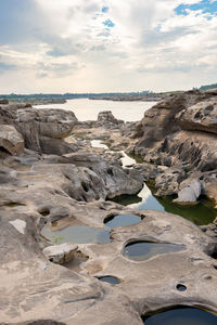 Scenic view of rocks on beach against sky