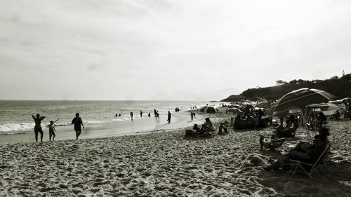 People at beach against sky