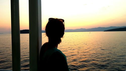 Silhouette woman against sea during sunset