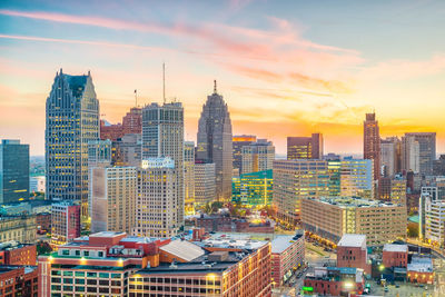 Modern buildings in city against sky during sunset