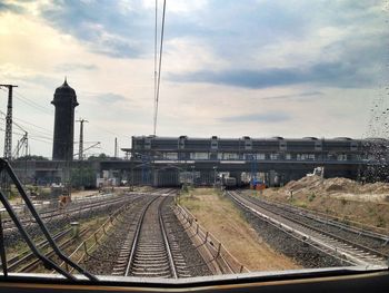 Railroad tracks against cloudy sky