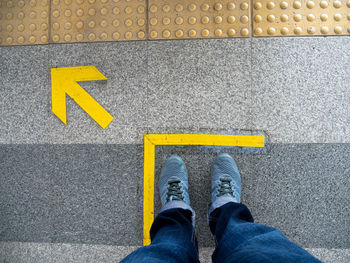 Low section of man standing on road