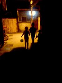 Silhouette people in illuminated room