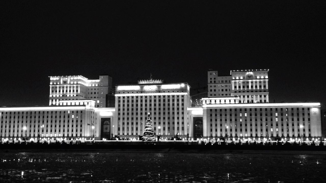 building exterior, architecture, built structure, clear sky, city, night, building, copy space, text, modern, waterfront, illuminated, tower, western script, skyscraper, outdoors, water, tall - high, office building, city life