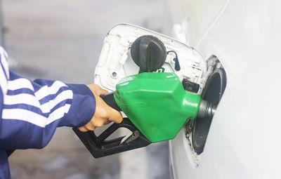 Cropped hand refueling car at gas station