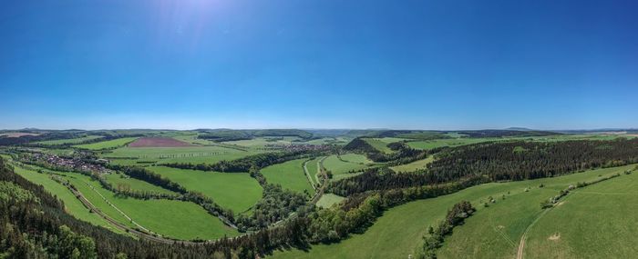 Scenic view of agricultural field against clear blue sky