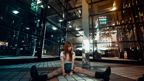 Woman sitting on floor in city