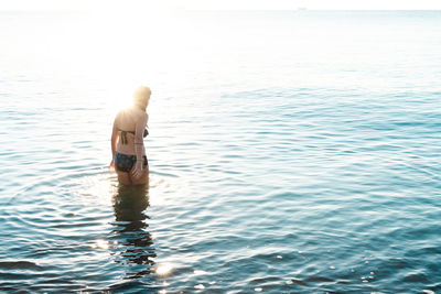 Rear view of shirtless man in sea