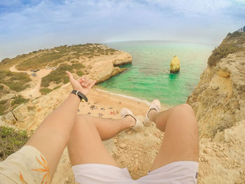 Low section of man relaxing on beach